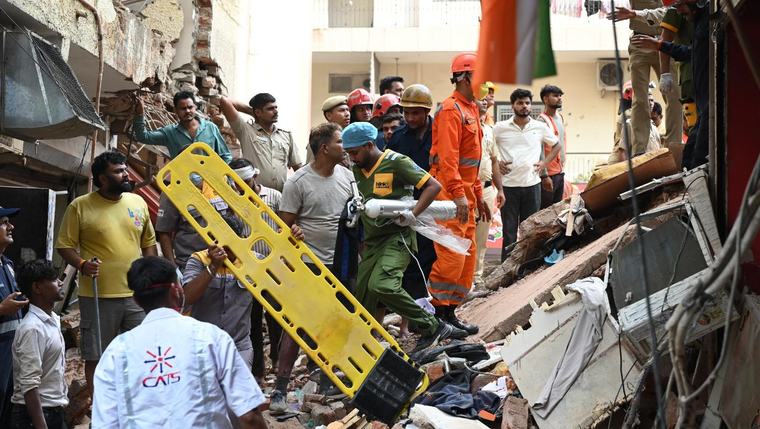 Building collapse in New Delhi kills 1 and traps dozens of others