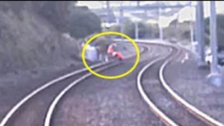 Train rounds bend to find worker on track, slams to a stop 5m from impact